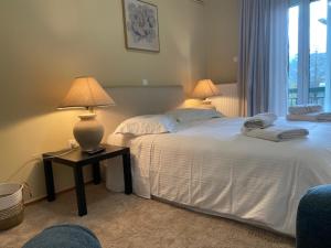 a bedroom with two beds and two lamps on a table at Elitee Superior Mountain Residence in Vitina