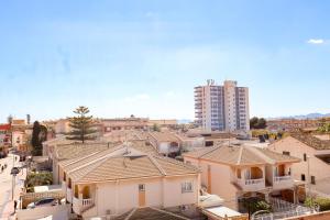a group of houses in a city with a tall building at Casa Joek in Los Alcázares