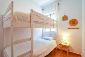 a bedroom with two bunk beds and a lamp at Casa Joek in Los Alcázares