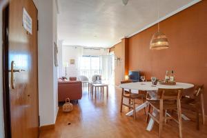 a dining room and living room with a table and chairs at Casa Joek in Los Alcázares