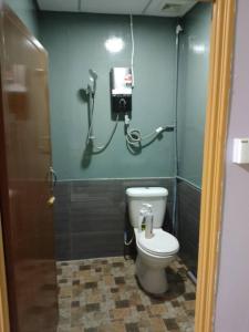 a bathroom with a toilet and a phone on the wall at kieara Redang Chalet in Kampong Pinang
