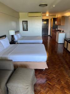 a hotel room with two beds and a couch at Boracay Malay Aklan Studio Unit in Boracay