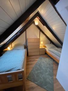 a attic room with two beds and a rug at Ferienhaus Norderwieke in Großefehn 