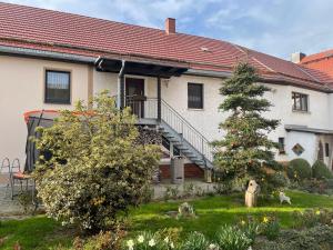 a house with a staircase and a tree in the yard at Ferienwohnung Dreyhaupt in Tegau
