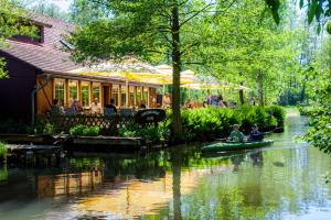 two people are riding in a canoe down a river at Pension Spreewaldhof Leipe in Leipe