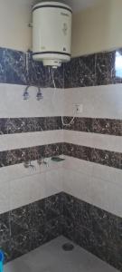 baño con lavabo y una luz en la pared en Hotel Anchal Residency, en Manali