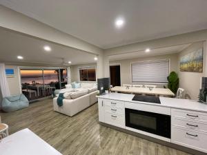 a kitchen and living room with a couch and a sink at Aqua Straddies Best View Bay, Brissy & Beyond in Dunwich