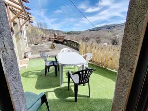 een patio met een tafel en stoelen op het gras bij les granges in Saint-Nectaire