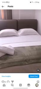 una foto de una cama con sábanas y almohadas blancas en Apartment Gjoli, en Durrës