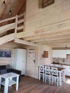 a kitchen with a table and chairs in a cabin at Domki Lawendowy Zakątek in Boszkowo