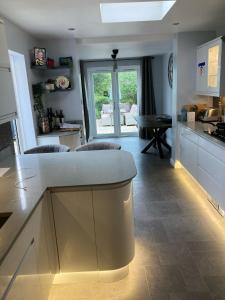 a kitchen with white cabinets and a counter top at Beautiful Property Close To London in Potters Bar