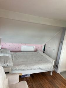 a bed with a pink headboard in a bedroom at Beautiful Property Close To London in Potters Bar +15 photos