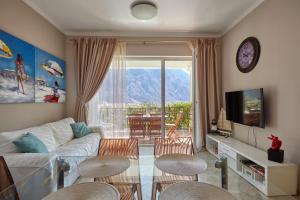 un salon avec un canapé, des chaises et une télévision dans l'établissement MonteBay Apart with POOL, à Gornji Orahovac