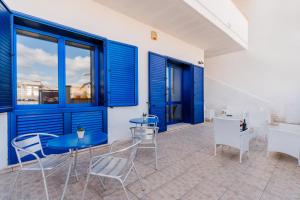 a patio with blue doors and tables and chairs at B&B Gioiello del Mare in Torre Lapillo