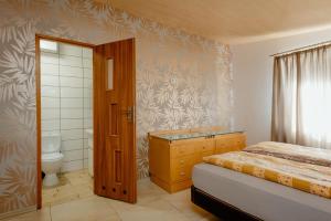 a small bedroom with a bed and a bathroom at Domki Leśne Uroczysko in Ustka