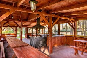 a large wooden cabin with a stove in the middle at Domki Leśne Uroczysko in Ustka