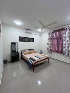 a bedroom with a bed and a ceiling fan at Selesa Homestay Beranang in Lengging