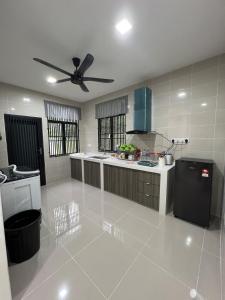 a large white kitchen with a ceiling fan at Selesa Homestay Beranang in Lengging