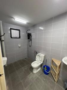 a bathroom with a toilet and a sink at Selesa Homestay Beranang in Lengging +4 photos