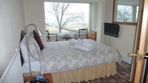 a bedroom with a bed with towels on it at Whitehall Guest House in Colwyn Bay