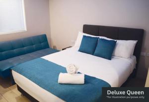 a bedroom with a large bed with a towel on it at Marco Polo Motor Inn Sydney Hotel in Sydney