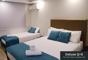 a hotel room with two beds with blue pillows at Marco Polo Motor Inn Sydney Hotel in Sydney +43 photos