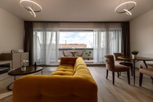 a living room with a yellow couch and a table at Magnolia Apartment Hotel in Budapest