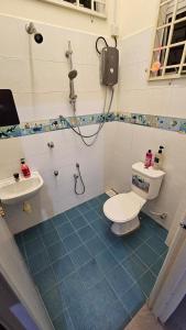 a bathroom with a toilet and a sink at Homestay ZaraMelly Kuala Terengganu in Kuala Terengganu