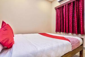 a bedroom with a bed with red curtains at Grand Ocean Inn in Puducherry +42 photos