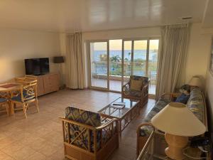 un soggiorno con divano, sedie e TV di Paradise Perch - Royal Retreats at Maho Beach a Lowlands Altre 27 foto