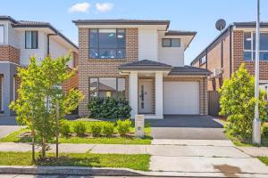a brick house with a garage at KozyGuru | Austral | Charming 4Bedroom Family Home in Austral