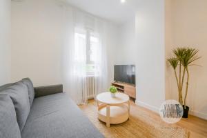 un salon avec un canapé et une table dans l'établissement Estilo con parking para 4, vive La Latina, à Madrid