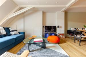 un salon avec un canapé bleu et une table dans l'établissement STRAS'LOFT - Hypercentre - Haut de Gamme - Cathédrale - Confort - Calme, à Strasbourg 26 autres photos