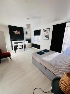 Un dormitorio con una cama grande y un escritorio. en London E2 Rooms, en Londres