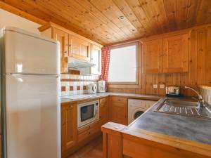 a kitchen with wooden cabinets and a refrigerator at Studio cabine 5 personnes à Arc 1600, ski aux pieds, proche commerces, wifi gratuit - FR-1-411-361 in Arc 1600