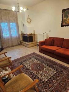 a living room with a red couch and a rug at Paikos Townhouse, Hot Springs in Konstantía