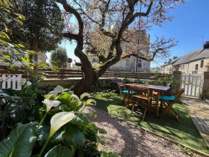 a table and chairs in a yard with a tree at Gîte Ke'R Maé in Le Quiou