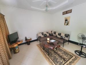 a living room with a couch and a tv at Philo Leisure Gardens in Kalangala