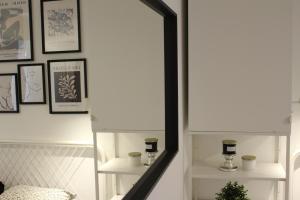 a hallway with a mirror and framed pictures on the wall at Nid cosy au vert idéal pour escapade romantique in Tohogne