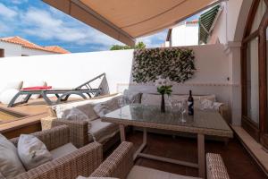 a patio with a couch and a table on a balcony at Villa Tricia 6 Bedroom Las Americas in Playa de las Americas