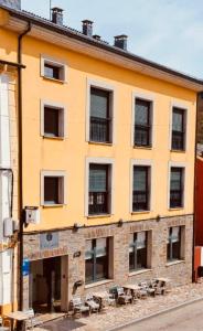 un edificio con tavoli e sedie di fronte di A Reigada Hotel Restaurante a Grandas de Salime