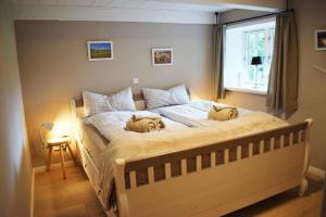 a bedroom with a bed with two dogs laying on it at Reetdachhaus Frieda Aventoft in Aventoft +22 photos