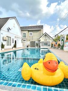 une piscine avec deux canards gonflables en caoutchouc dans l'eau dans l'établissement Margos Homestay 15mins to MotoGP, à Buriram