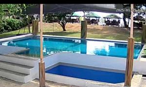 a swimming pool with blue water and stairs in it at Silong Bitaoy Beach Resort in Santa Cruz