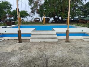 a person on a swing in front of a pool at Silong Bitaoy Beach Resort in Santa Cruz