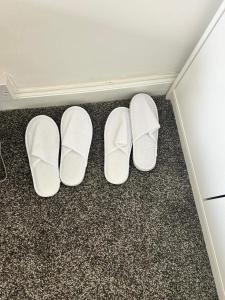 deux paires de chaussures blanches sur le sol dans une pièce dans l'établissement Cosy 3-Bed Retreat - Garden Parking & Bbq, à Birmingham 12 autres photos