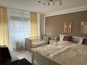 a bedroom with a large bed and a crib at Ferienhaus Morgenstern in Wilhelmshaven