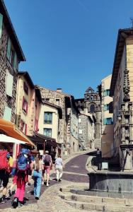 un grupo de personas caminando por una calle de la ciudad en La Traboule Ponote proche Gr65, en Le Puy en Velay