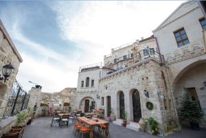 un bâtiment avec des tables et des chaises dans une cour dans l'établissement Asuwari Suites Cappadocia, à Ürgüp