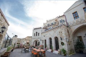 a building with tables and chairs in a courtyard at Asuwari Suites Cappadocia in Ürgüp
